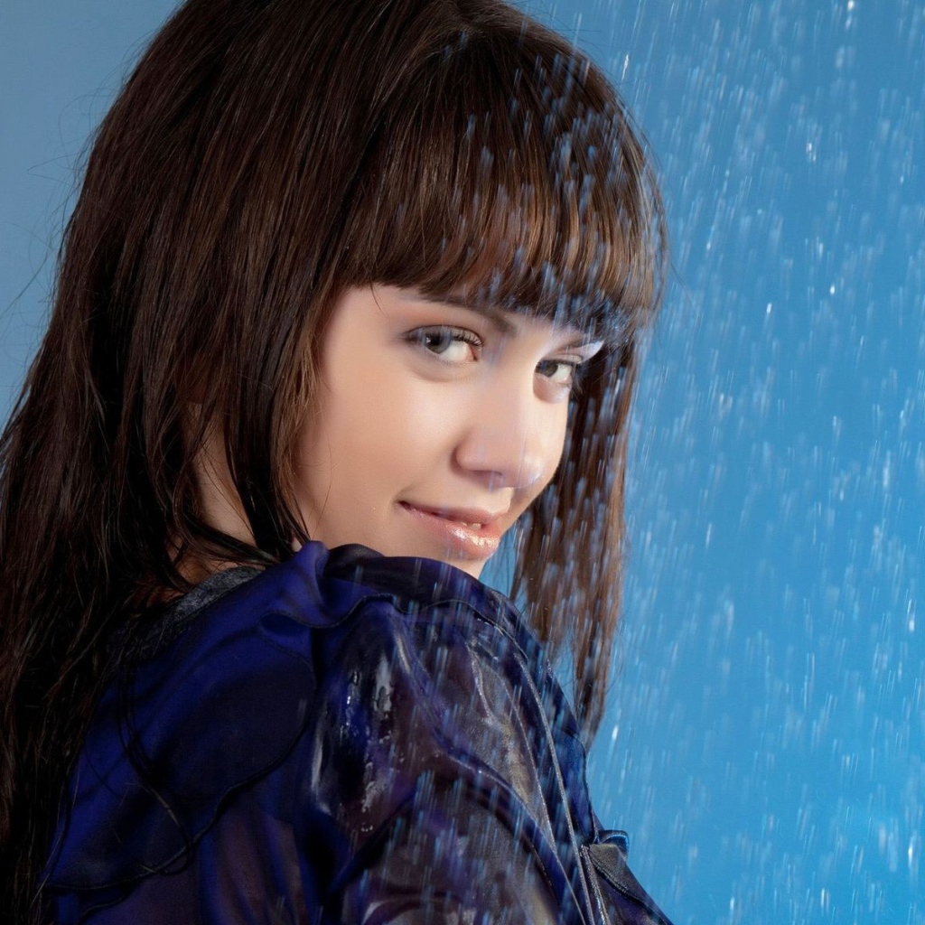 Девушка стоит под струей воды