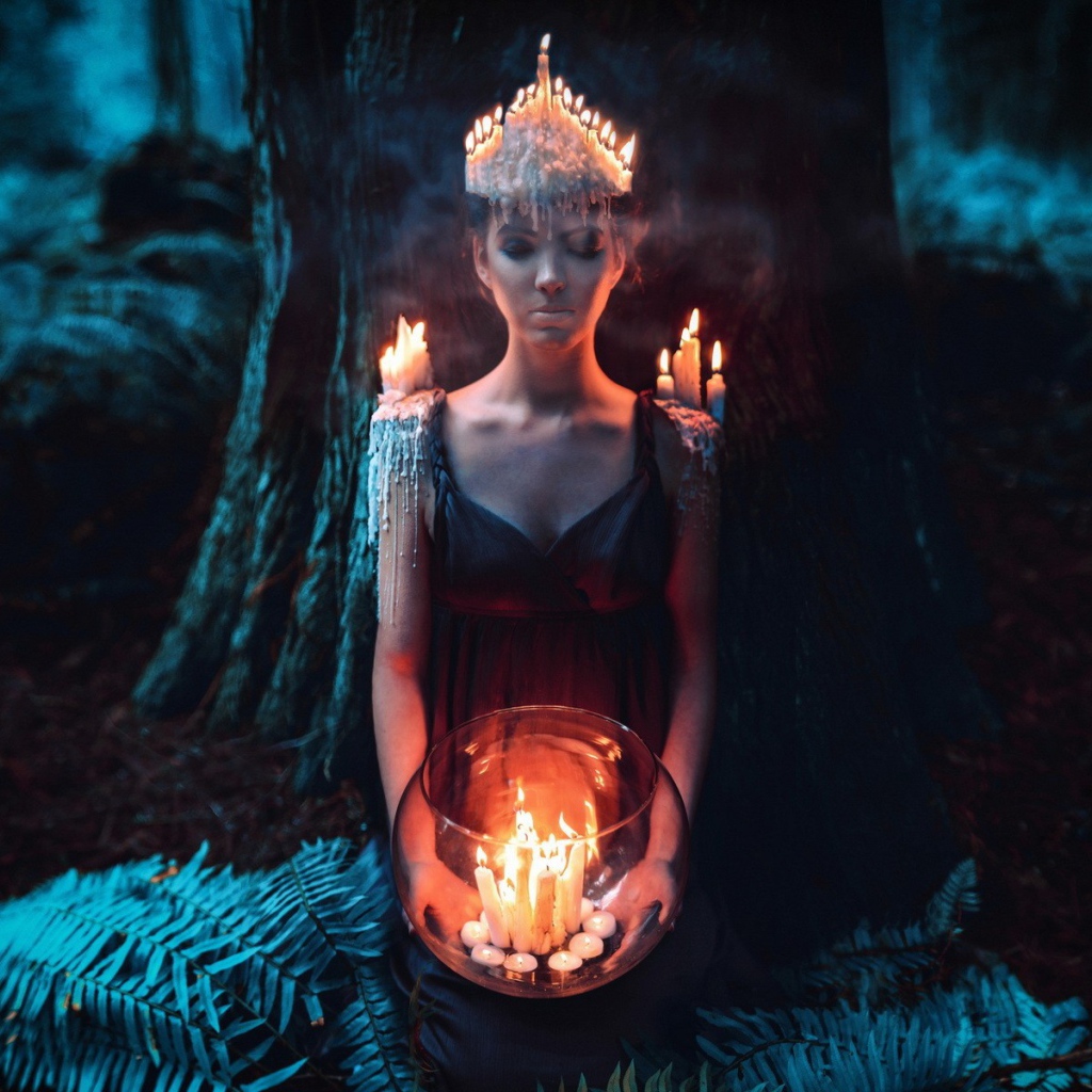 Девушка в окружении свечей в лесу