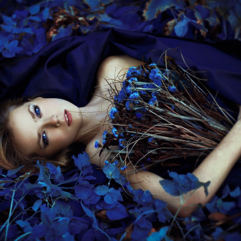 Девушка с букетом среди синих цветов