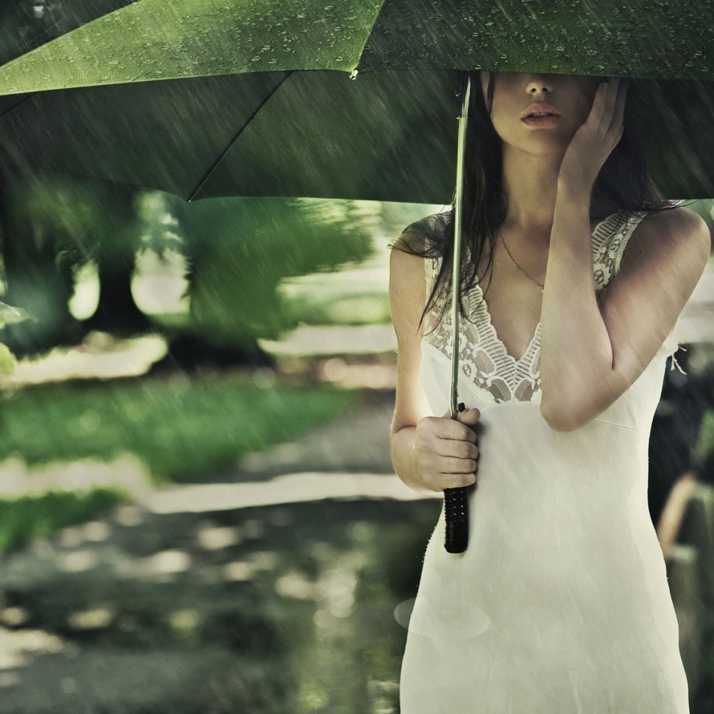 Девушка под зеленым зонтом во время дождя