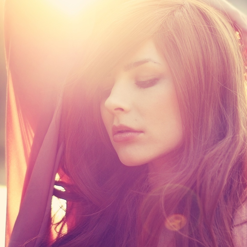 Девушка с каштановыми волосами в лучах солнца