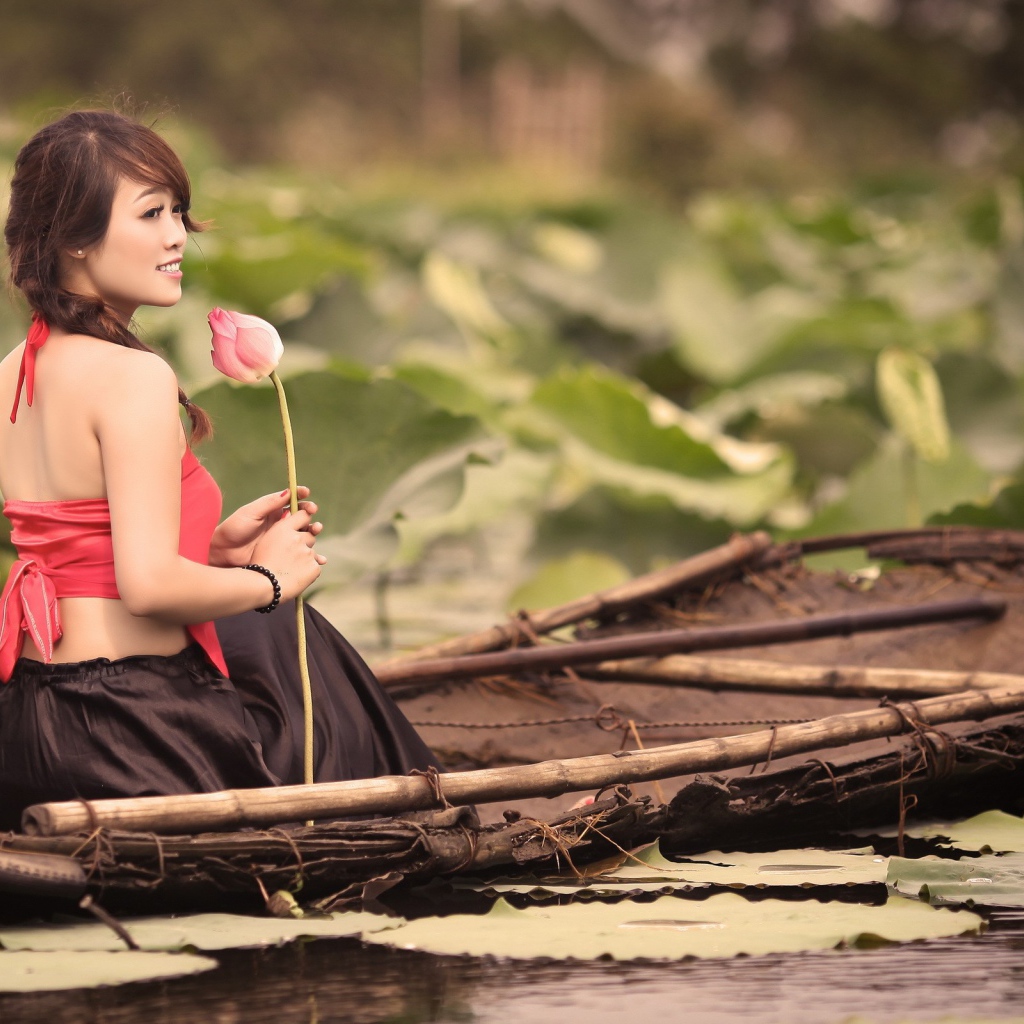Девушка с цветком сидит в лодке