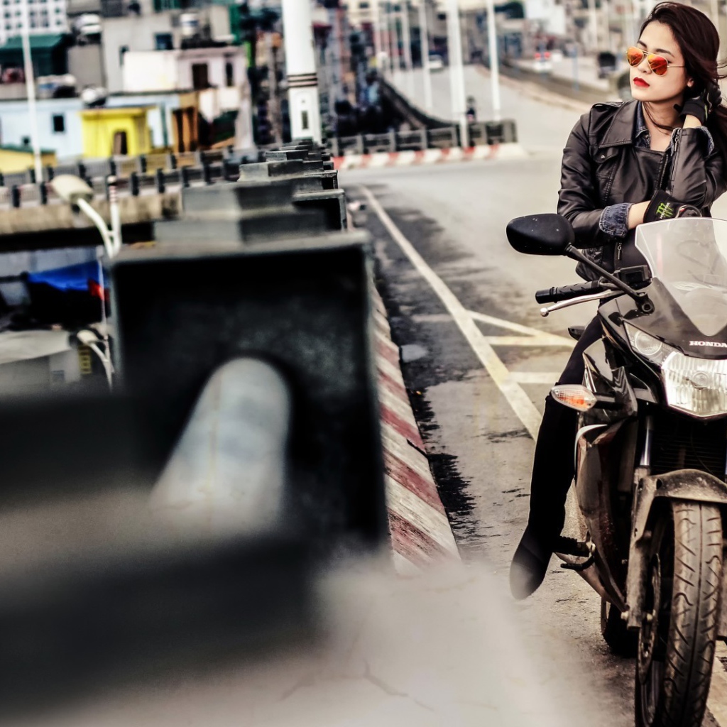 Девушка в темных очках сидит на мотоцикле