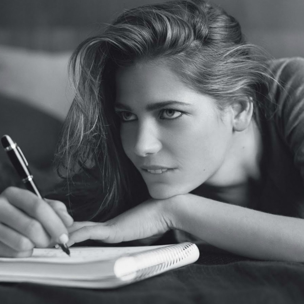 Девушка пишет в блокноте