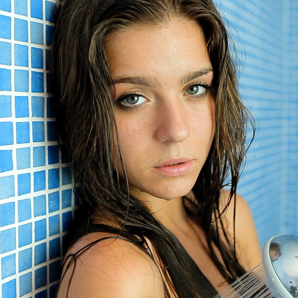 Зеленоглазая брюнетка стоит в душе