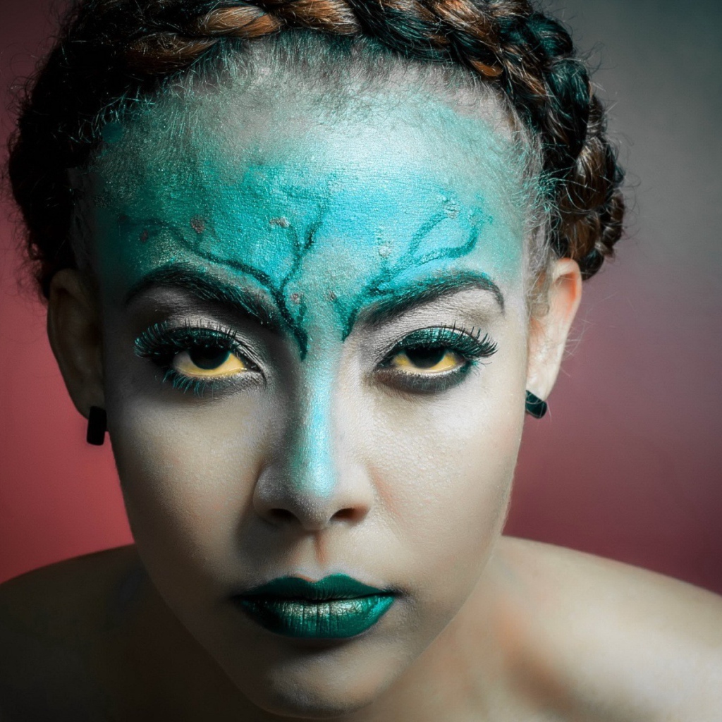Зеленая краска на лице у девушки