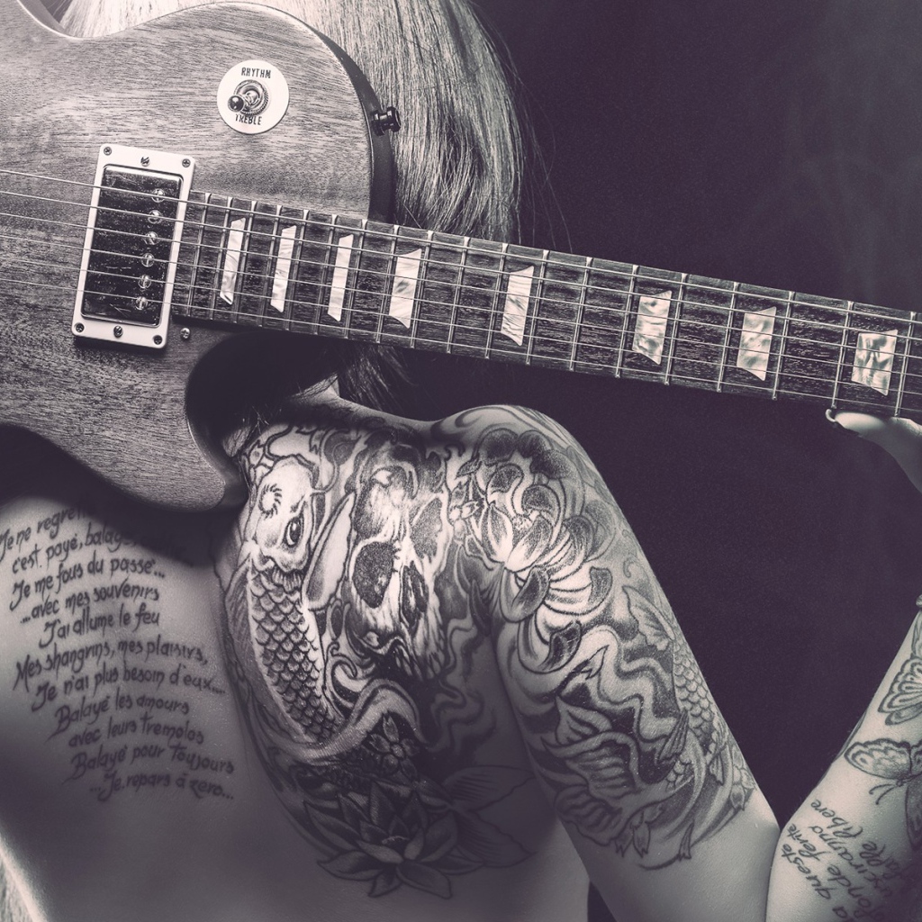Гитара на спине татуированной девушки