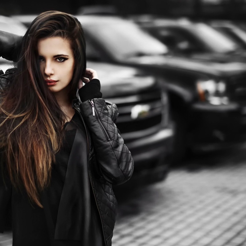Черноволосая девушка на фоне черных автомобилей
