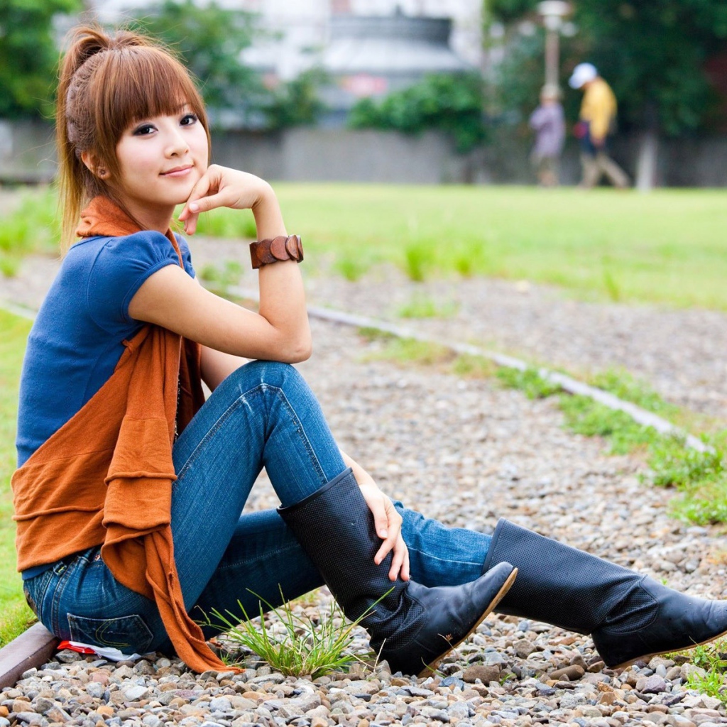 Японская девушка сидит на трамвайном пути