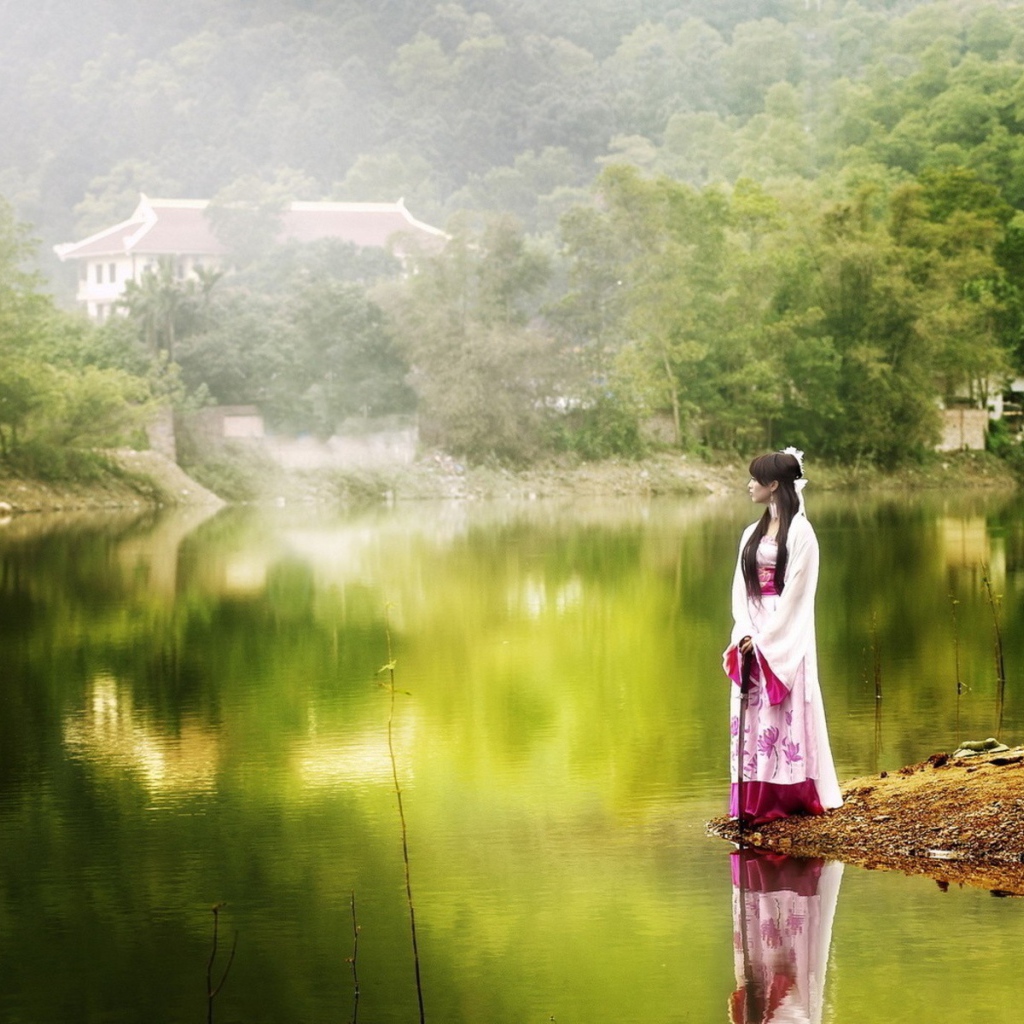 Японская девушка стоит на берегу водоема