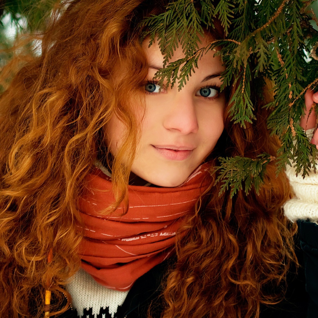 Рыжая девушка под ветками ели