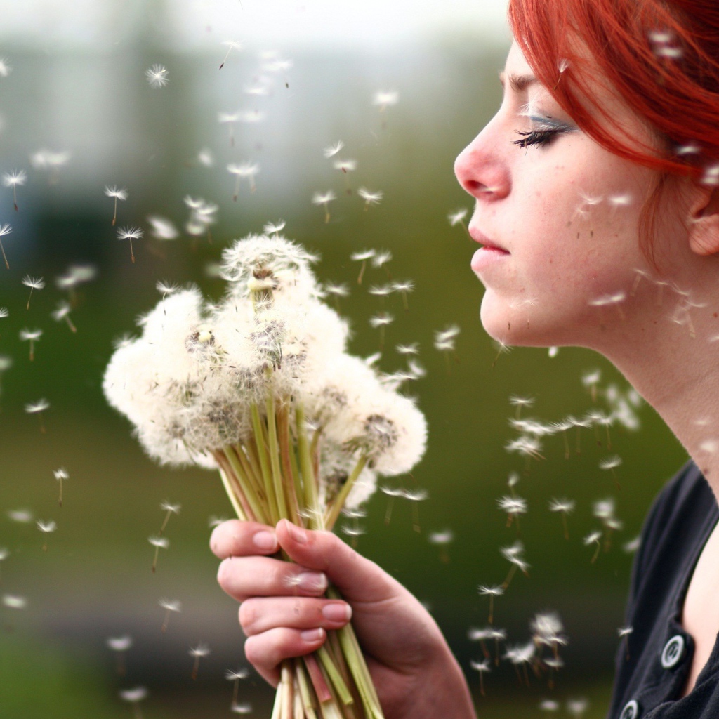Рыжая девушка с букетом зрелых одуванчиков