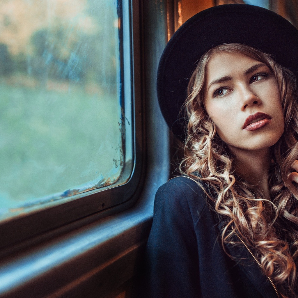 Романтичная девушка смотрит в окно