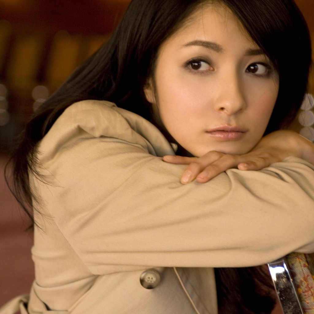Грустная азиатская девушка в коричневом плаще