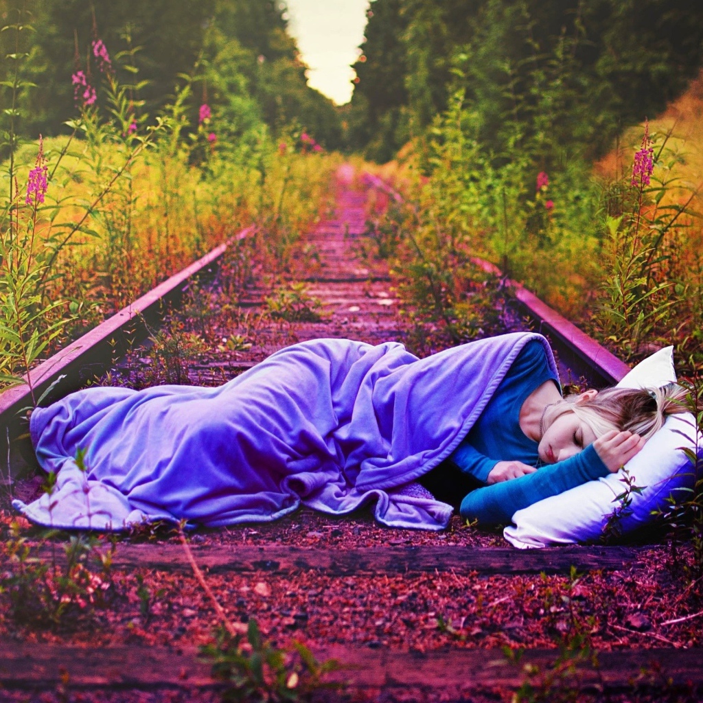 Девушка спит на заброшенных рельсах