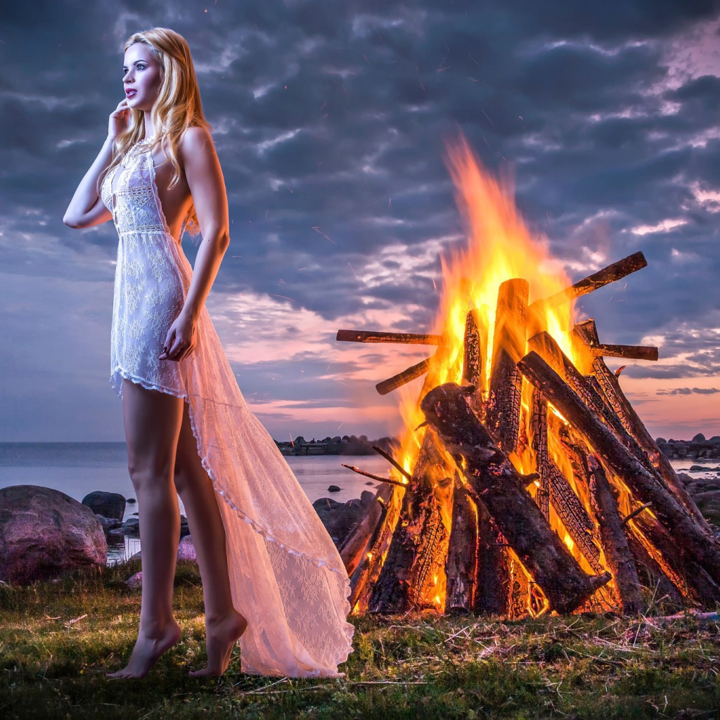Девушка у костра на берегу океана