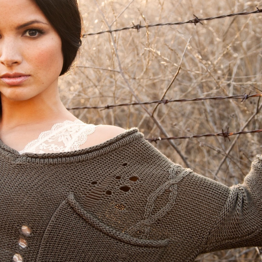 Девушка у забора из колючей проволоки