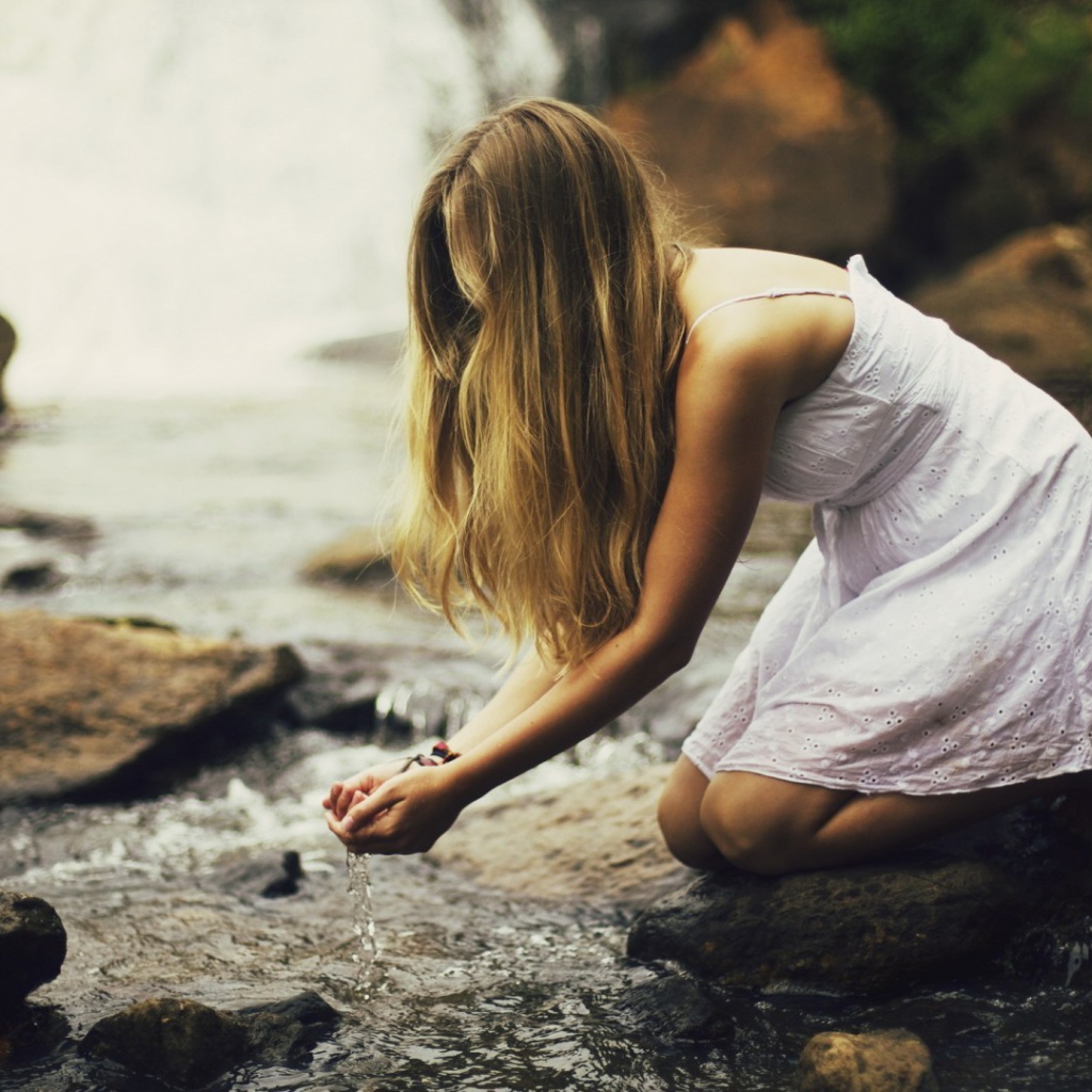 Девушка черпает воду из ручья