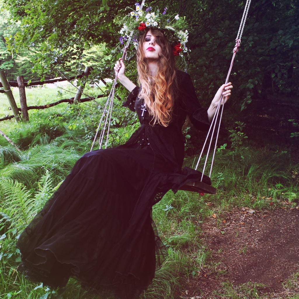 Девушка в черном платье на качели