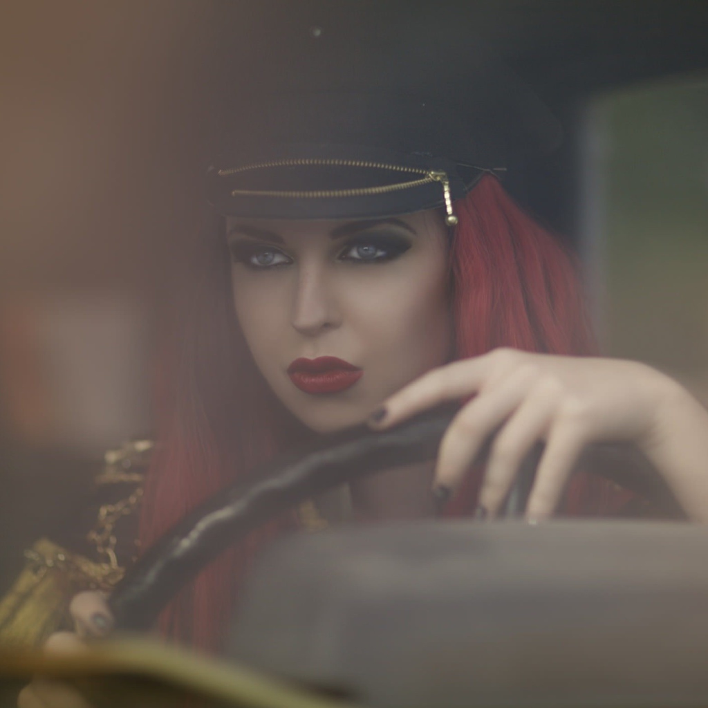 Девушка в фуражке за рулем