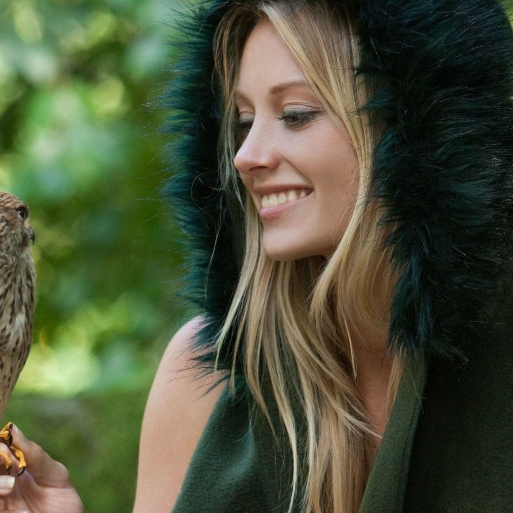 Девушка в меховой накидке держит на руке птицу