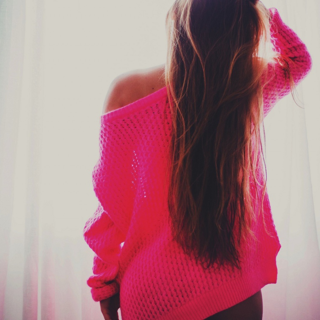 Девушка в розовой кофте стоит спиной