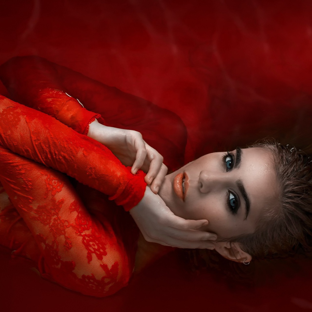 Девушка в красном кружевном платье на красном фоне