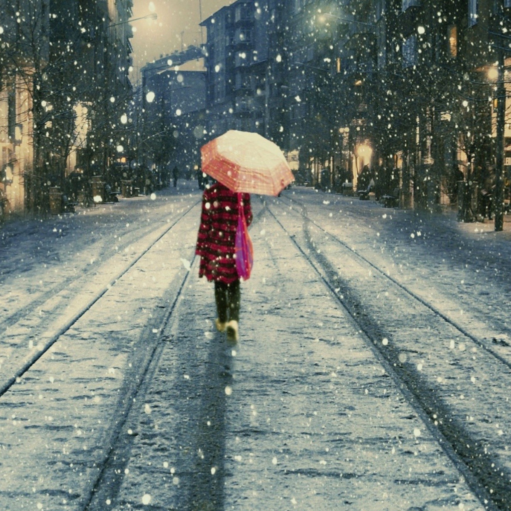 Девушка под дождем идет вдаль по улице