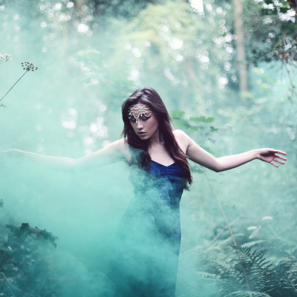 Девушка идет среди дыма по лесу