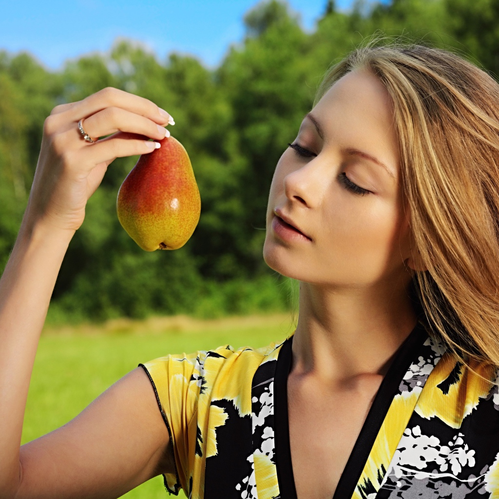 Девушка смотрит на грушу