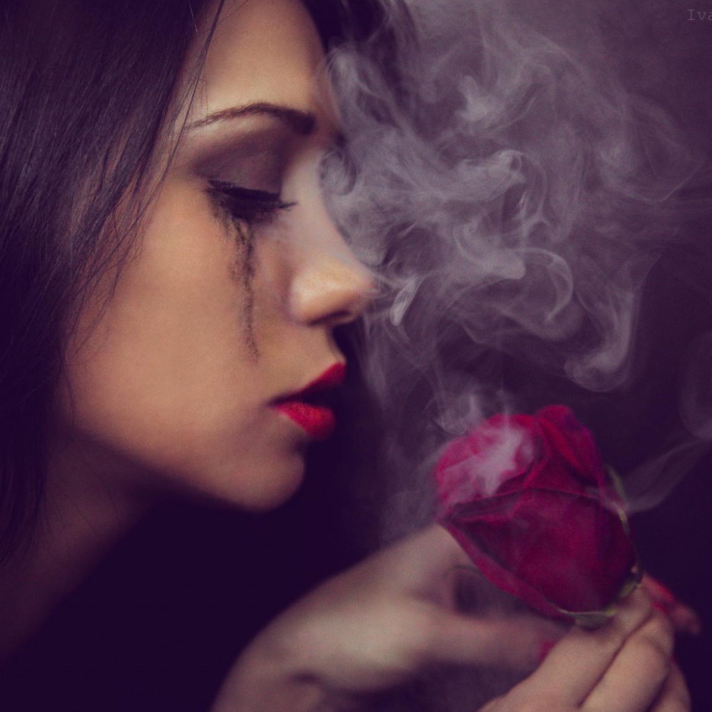 Девушка смотрит на дымящуюся розу