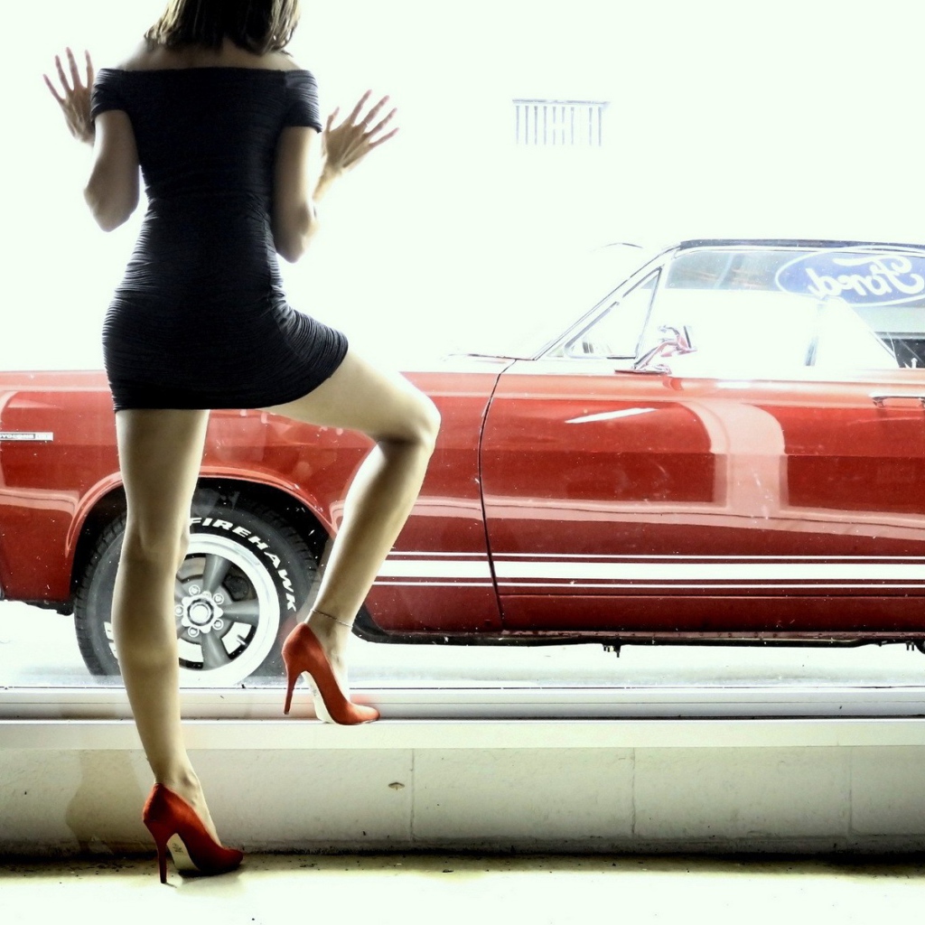 Девушка смотрит в окно на красный автомобиль