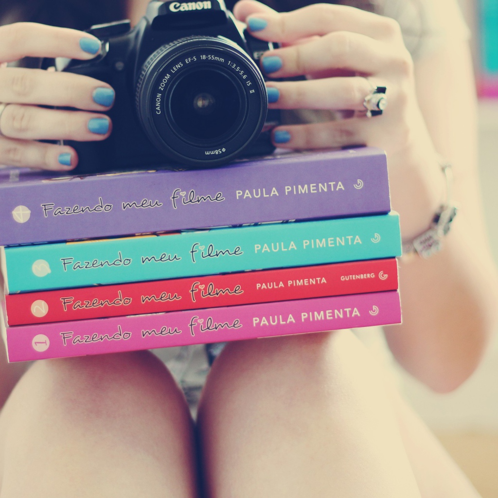 Девушка фотограф со стопкой книг