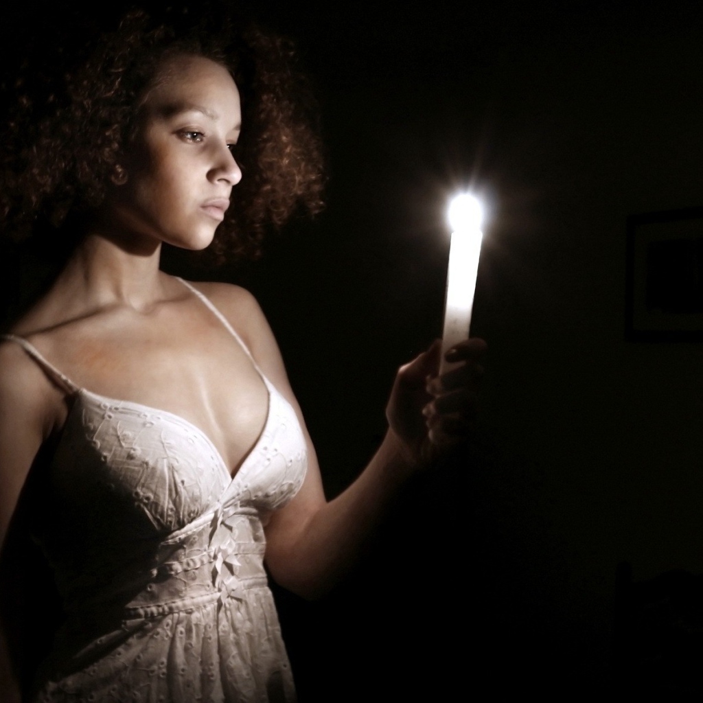 Девушка со свечой в темноте