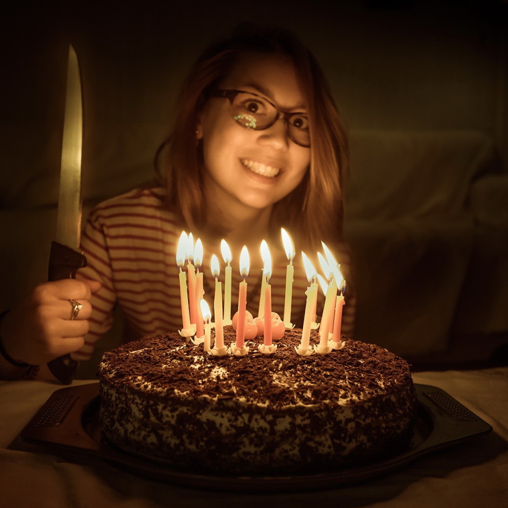 Девушка с ножом у праздничного торта