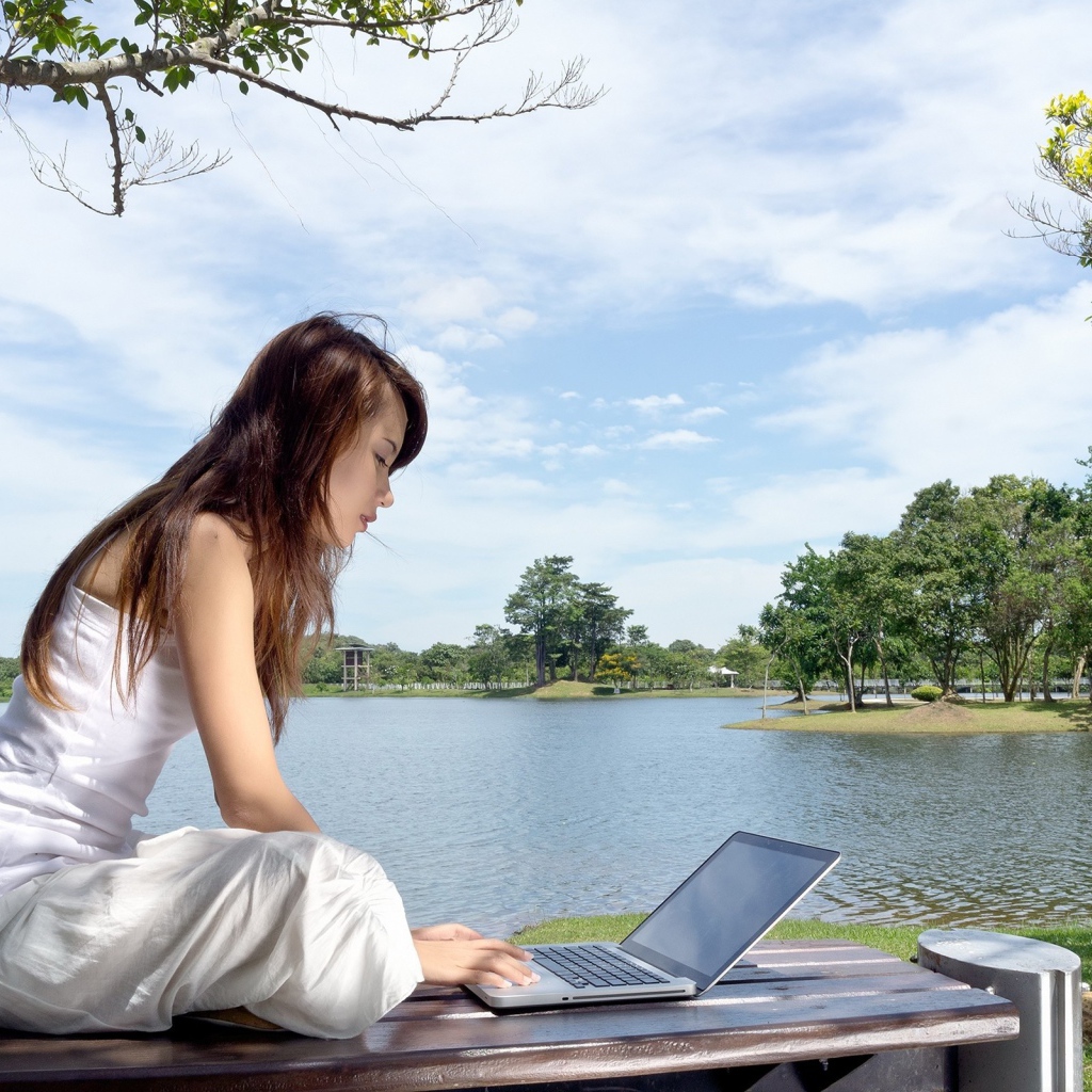 Девушка с ноутбуком у озера