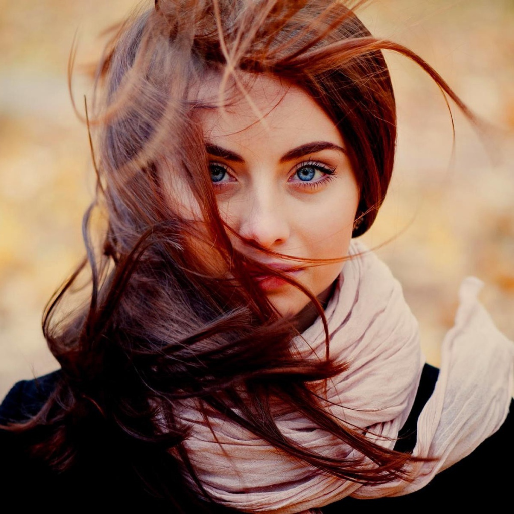 Ветер треплет волосы у девушки