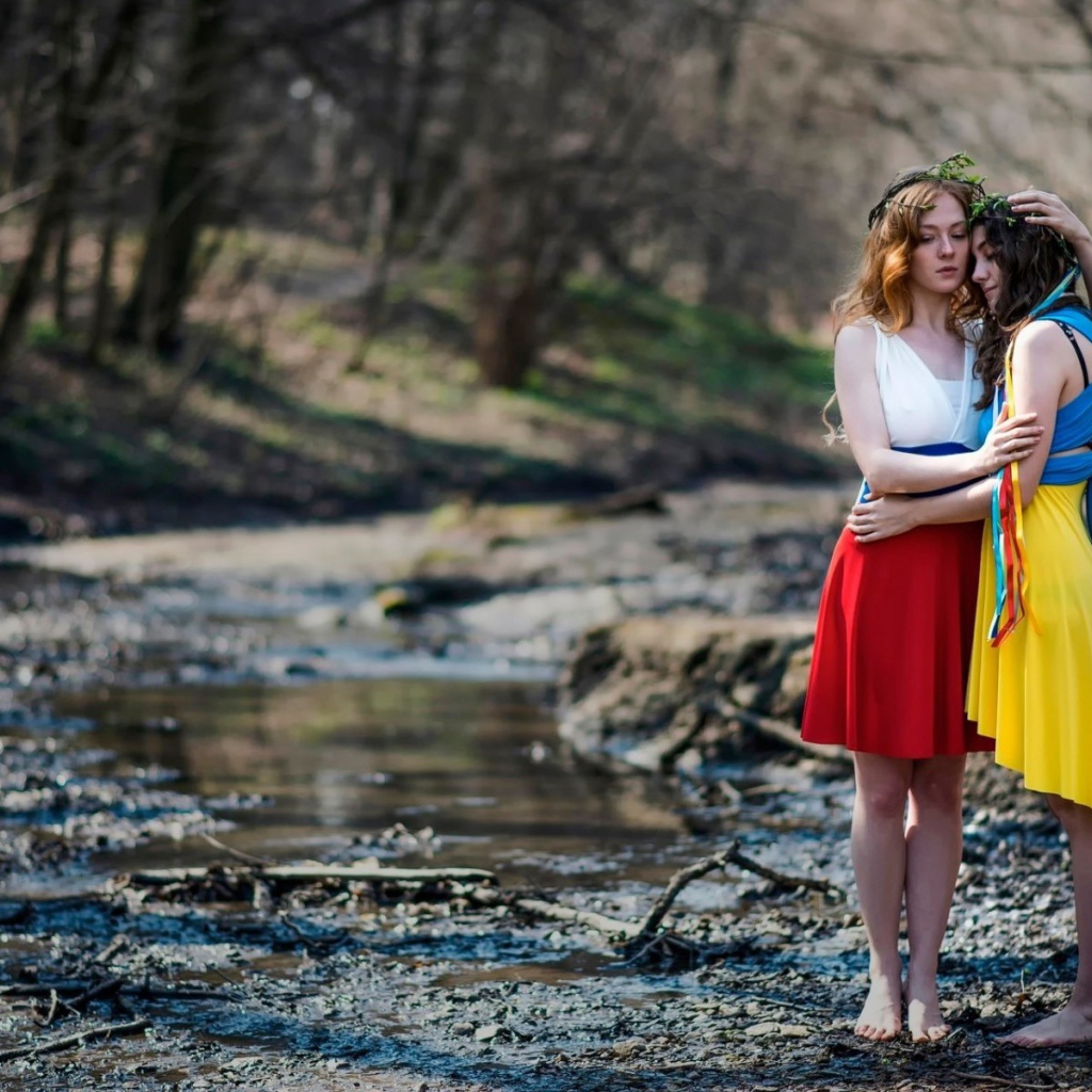 Две девушки в ярких платьях в чаще леса