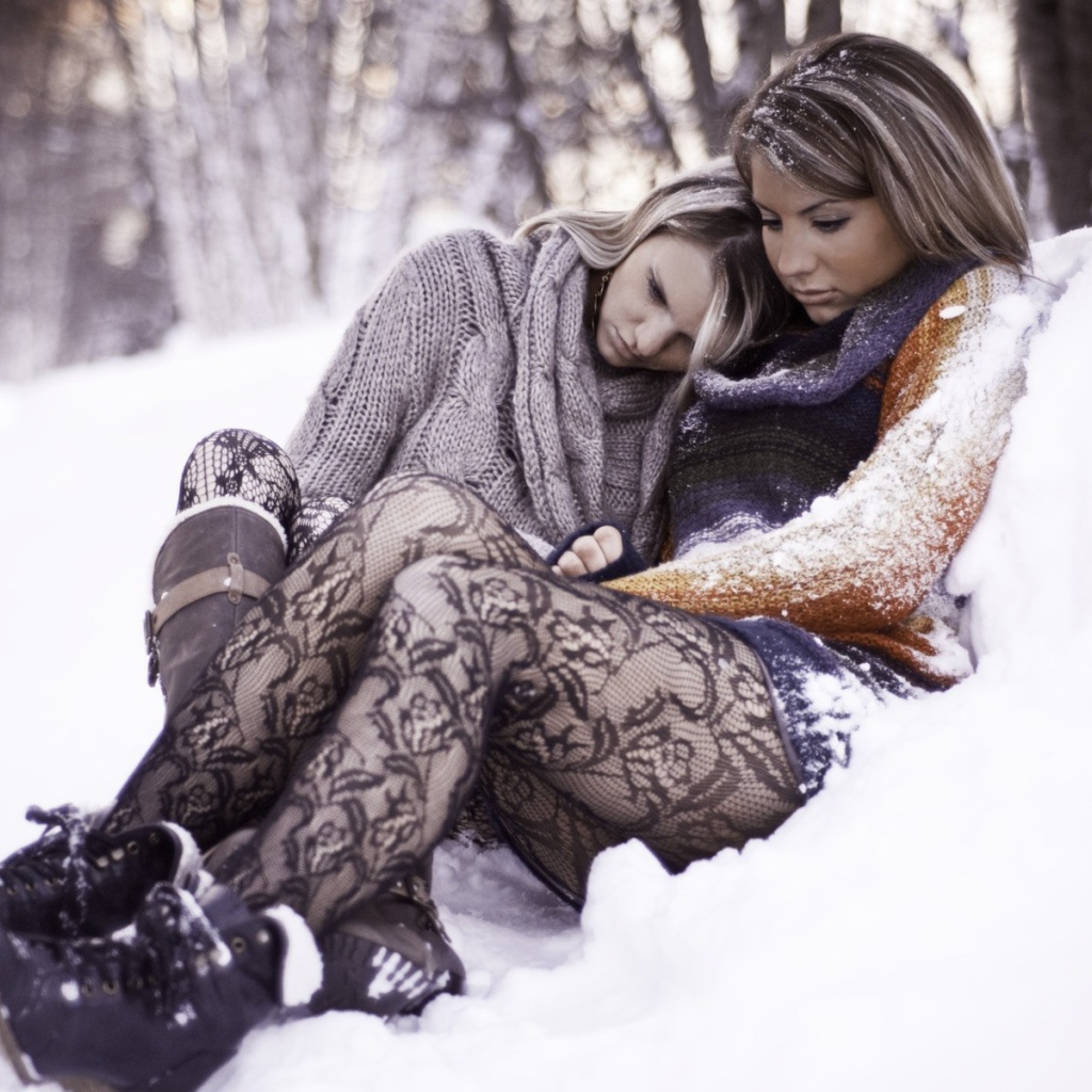 Две девушки сидят в снегу