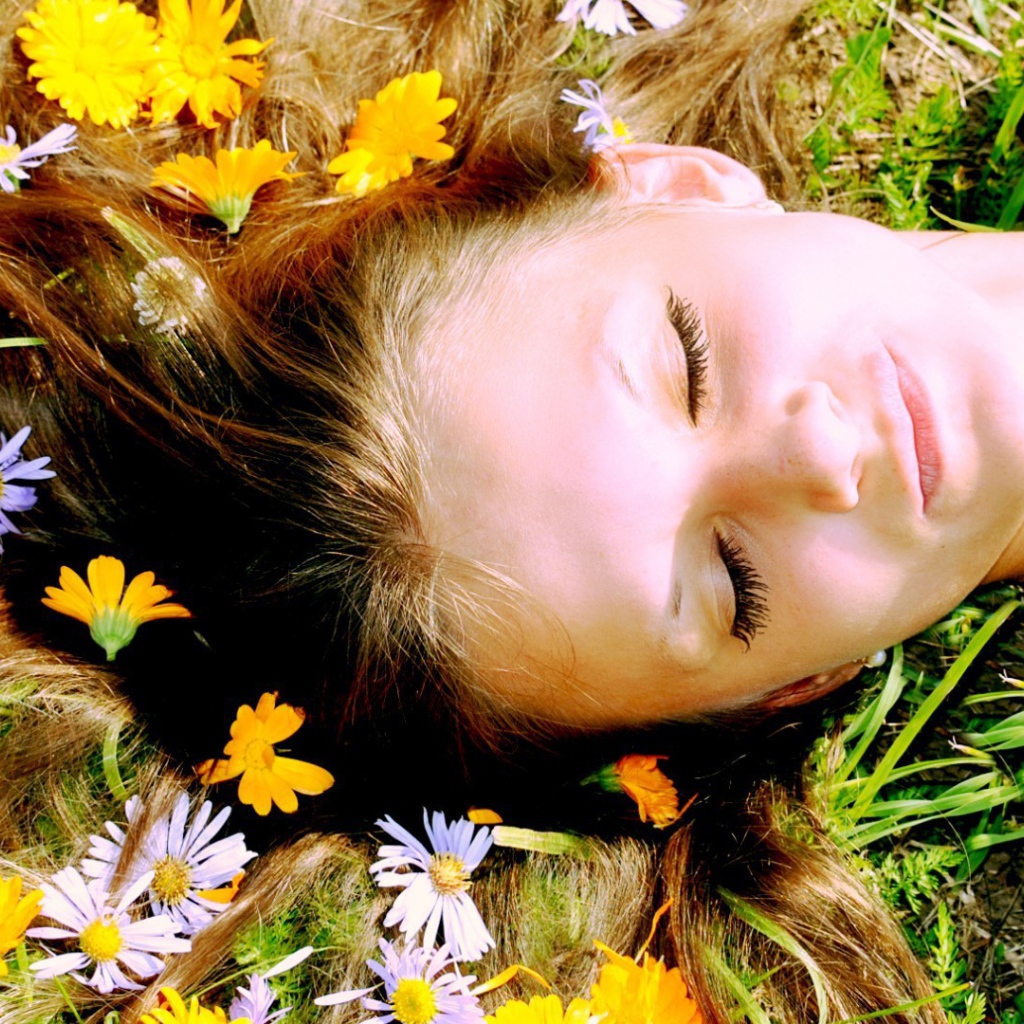 Белые и желтые цветы в волосах у девушки