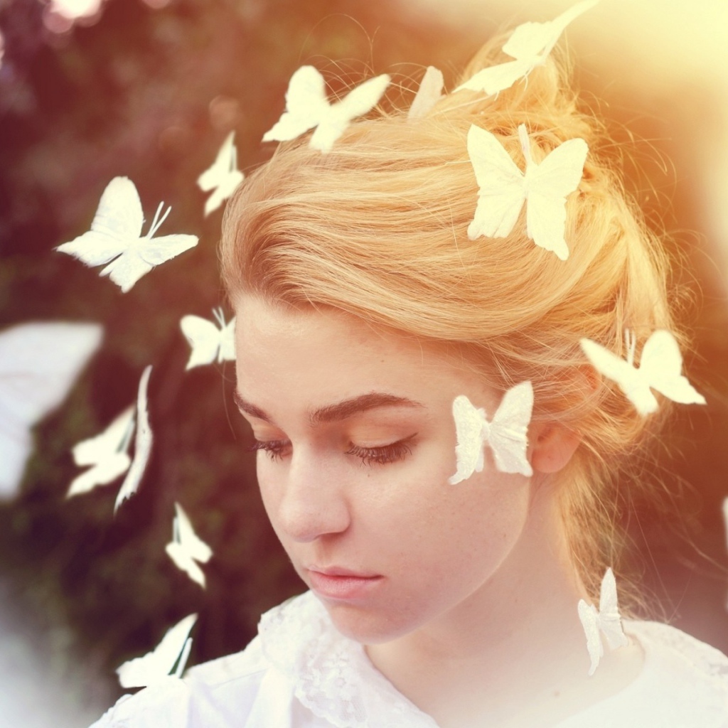 Белые бабочки летают вокруг девушки