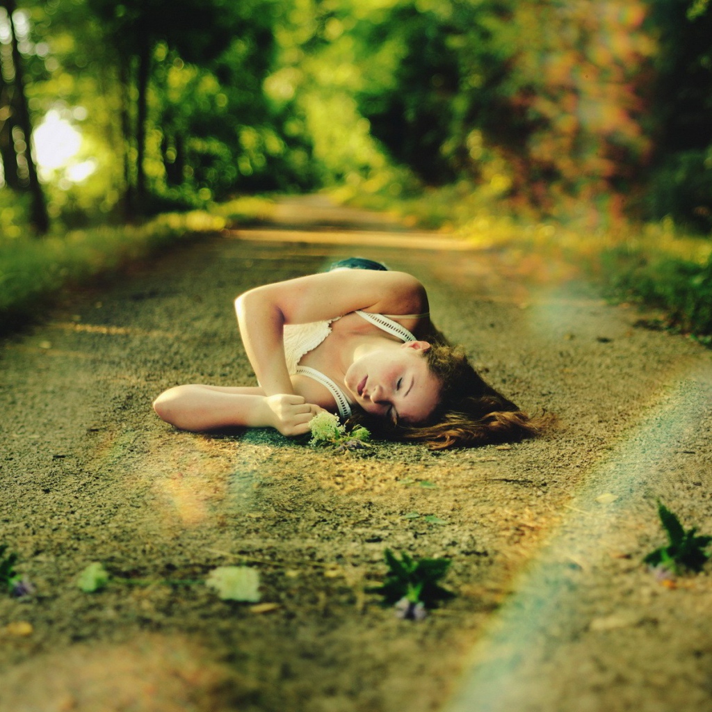 Женщина спит на лесной дороге