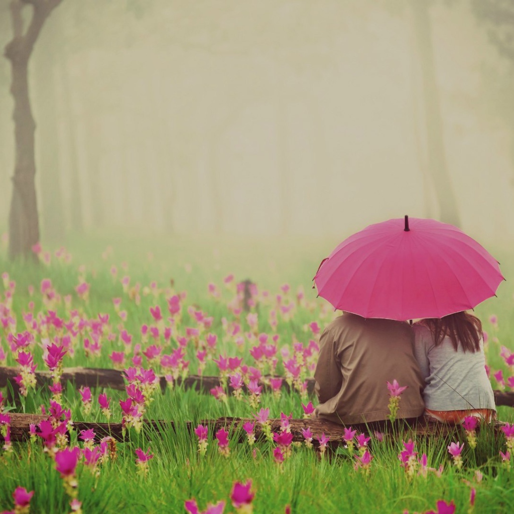 Двое сидят под зонтом