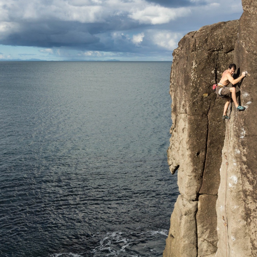 Мужчина скалолаз на скале над морем