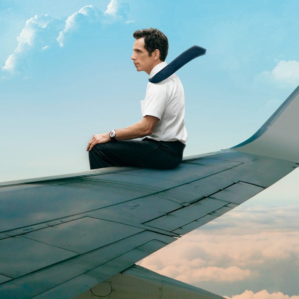 Мужчина сидит на крыле самолета