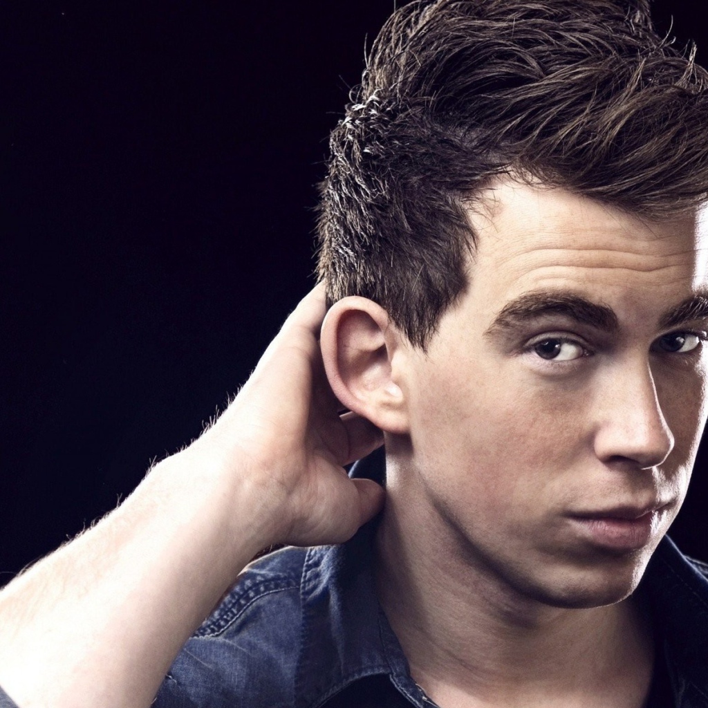 Молодой парень чешет затылок