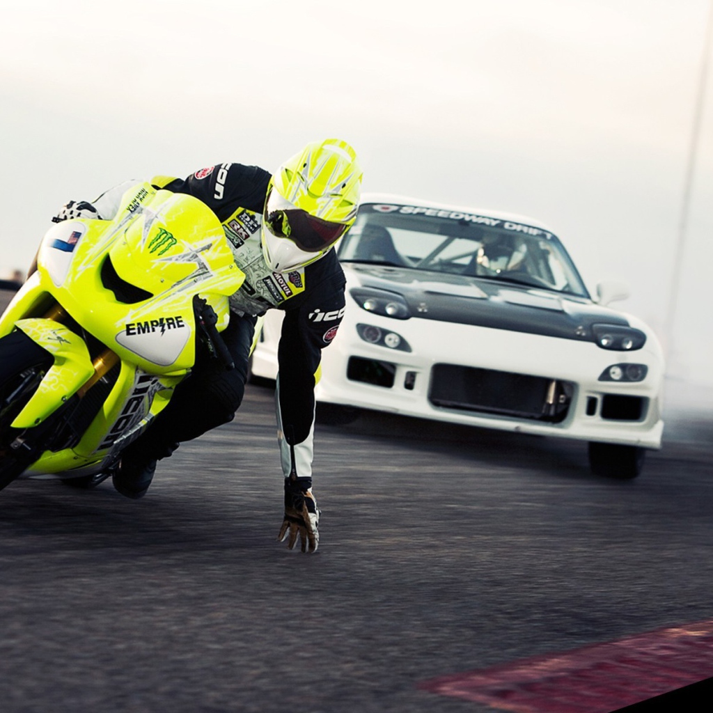 Мотоциклист касается рукой поверхности трека