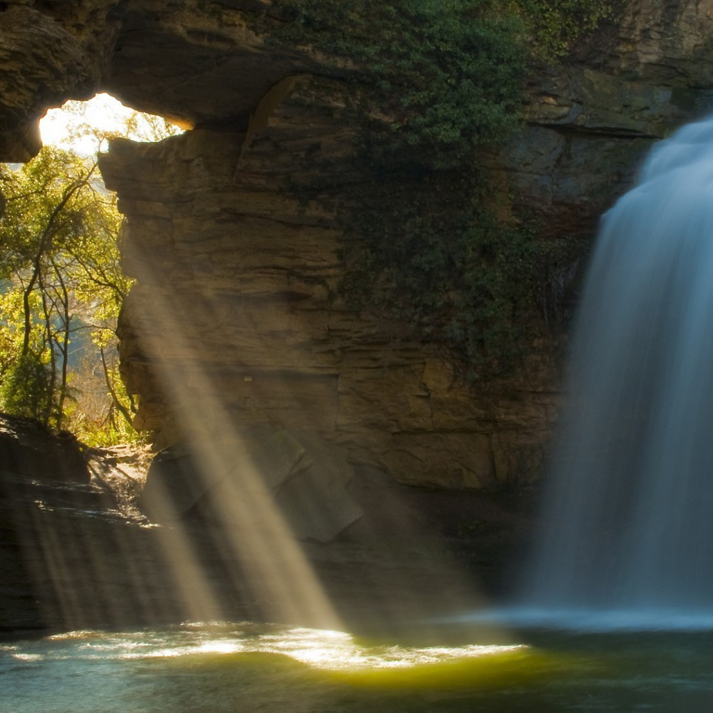 Лучи солнца и вода падают в пещеру