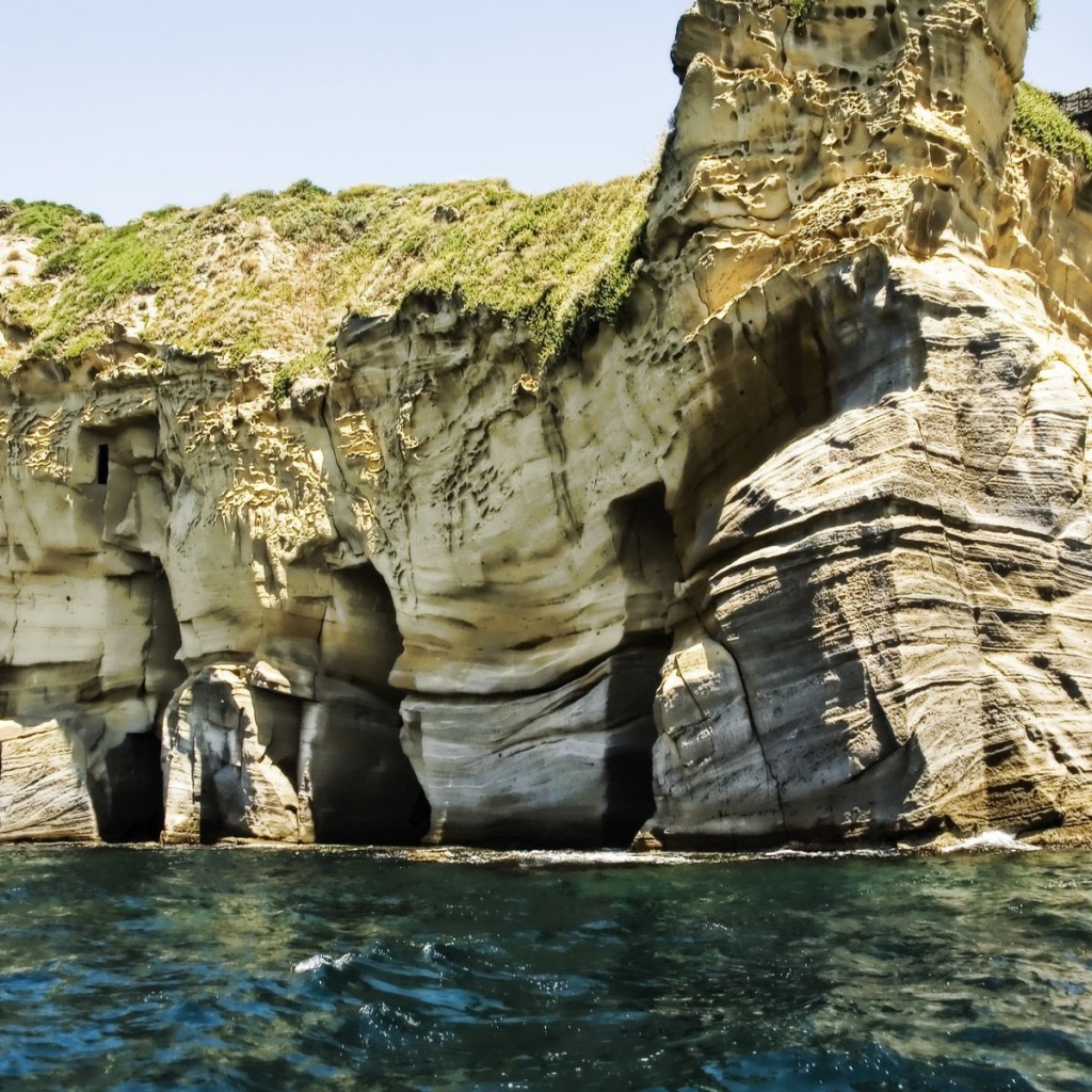 Промоины в основании скалы у моря