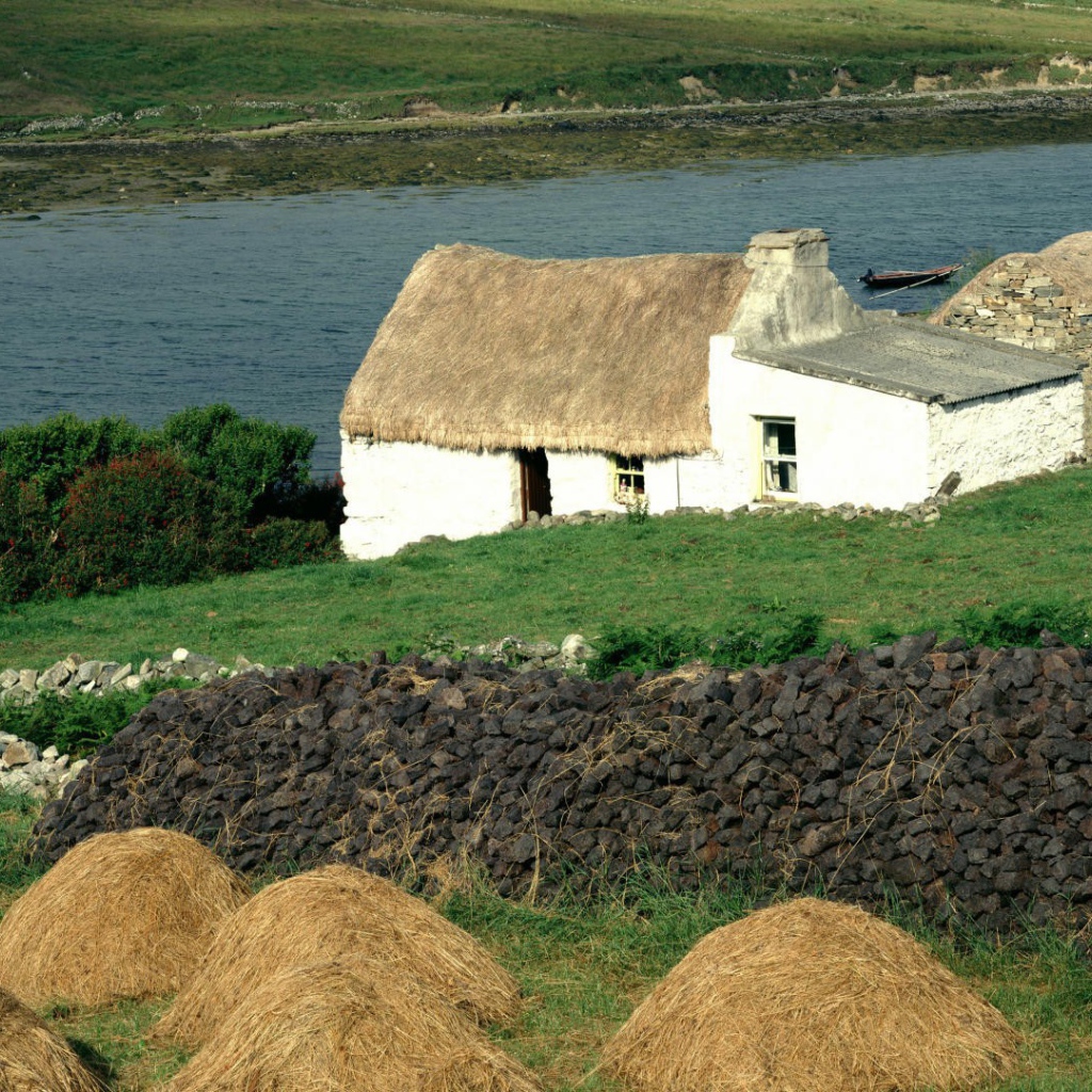Покрытый соломой дом на берегу реки